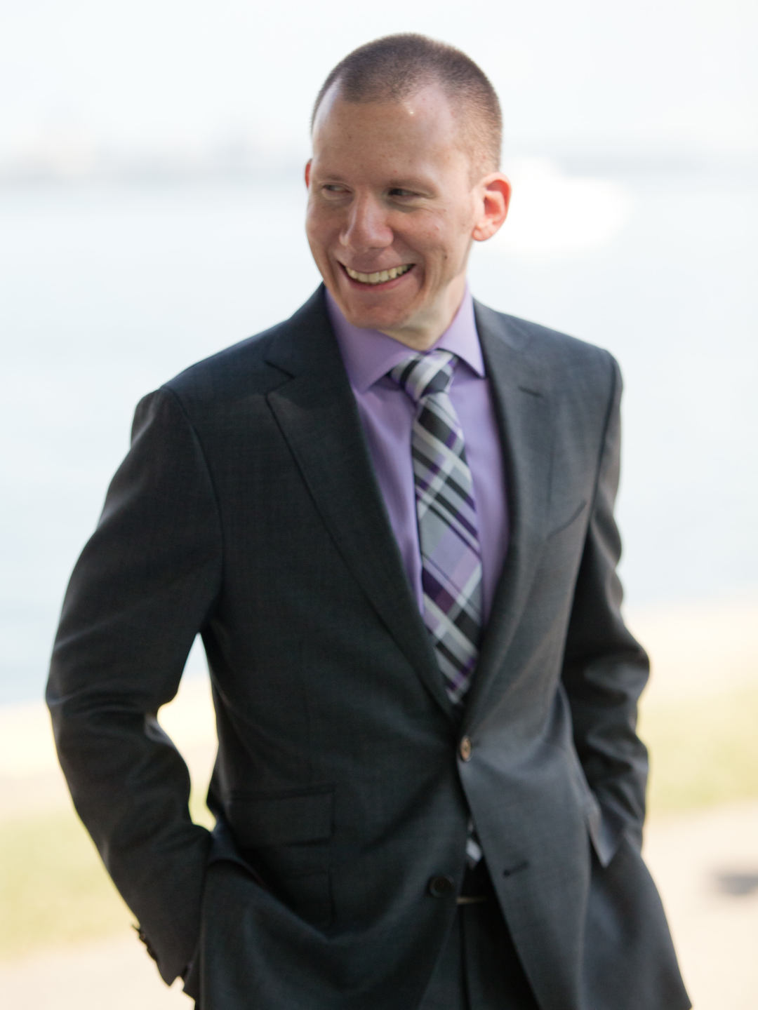 Carlo, founder of Big Bang Visibility, standing confidently in a dark suit against a neutral background.